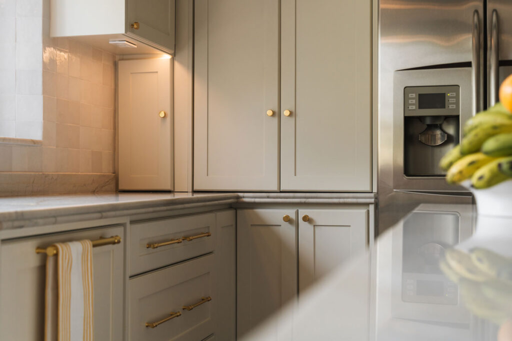 Isla de cocina en negro mate con cubierta blanca tipo cuarzo y cocina de induccion integrada.